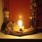 Lampe unique sur socle en bois flotté avec une ampoule Edison sur un meuble moderne allumée latérale