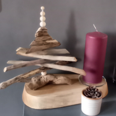 Sculpture de sapin de Noël en bois flotté avec des perles blanches sur un socle ovale en bois.